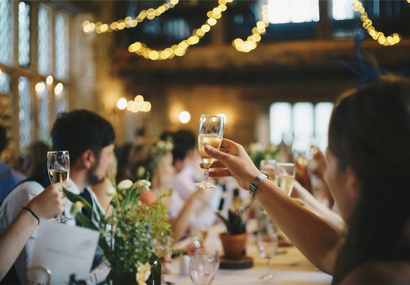 Guests raising glasses at an elegant dinner celebration