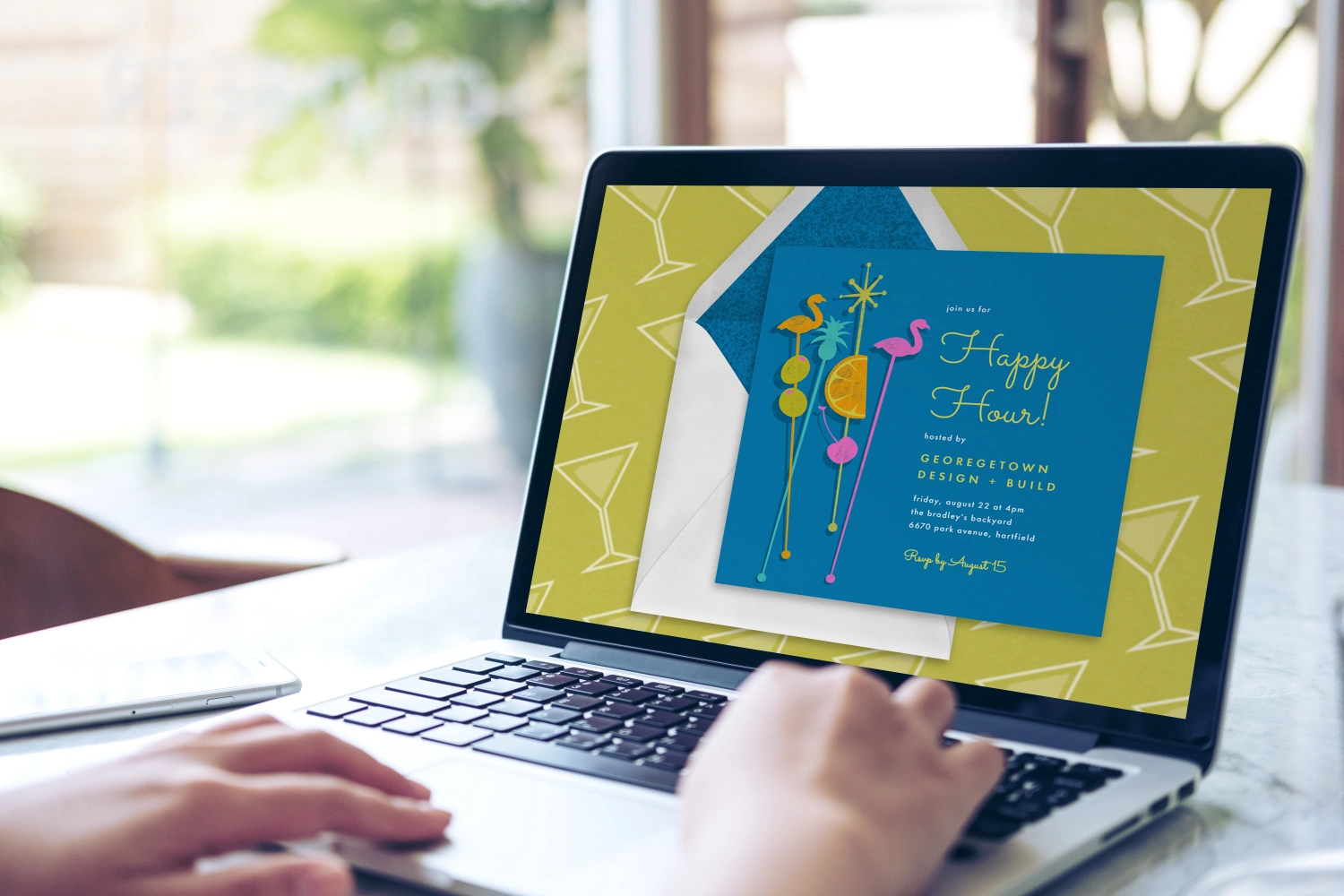 Laptop showing a Greenvelope digital invitation with envelope preview